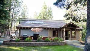 A cabin with a patio area, a grill, and a covered seating area. - 113 Standard Condo (Mammoth Lakes)