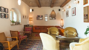A cozy living room with a sofa, armchairs, a coffee table, and a bookshelf. - Luis Stadl (Regensburg)
