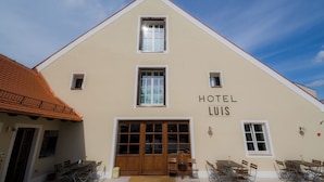A hotel with a beige facade, a tiled roof, and a sign reading 'HOTEL LUIS.' - Luis Stadl (Regensburg)