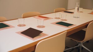 A conference room with a long table, chairs, a water bottle, and a smartphone on the table. - H La Paloma Boutique (Barcelona)