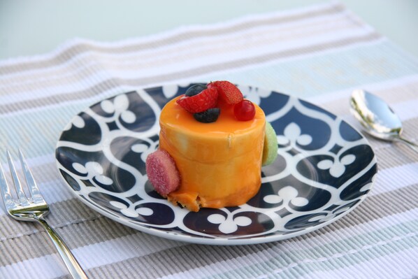 Un dessert servi dans une assiette à motifs, avec une fourchette et une cuillère à côté.