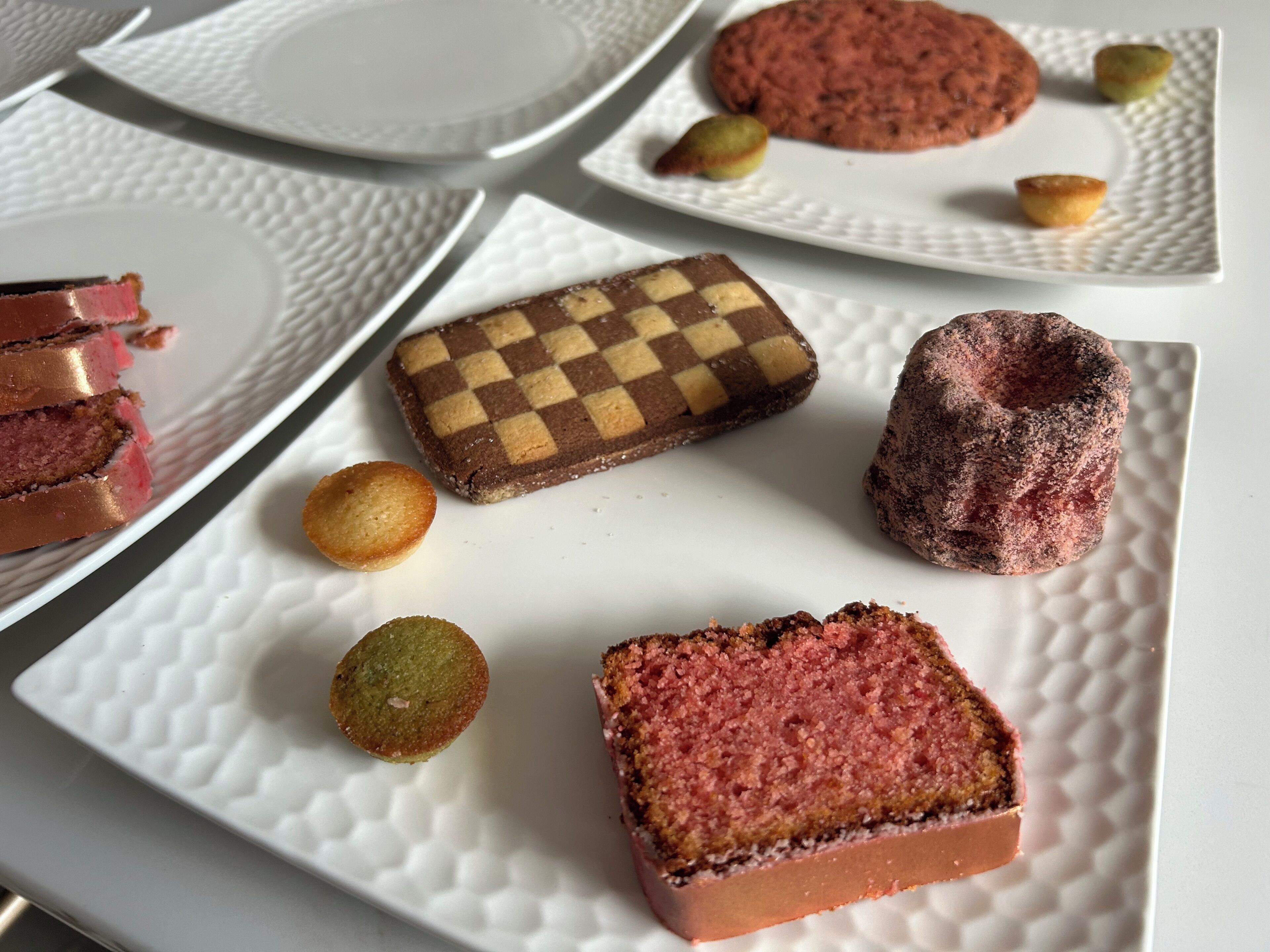 A variety of desserts on white plates with textured patterns.