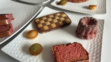A variety of desserts on white plates with textured patterns.