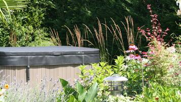 A hot tub surrounded by lush greenery and various plants.
