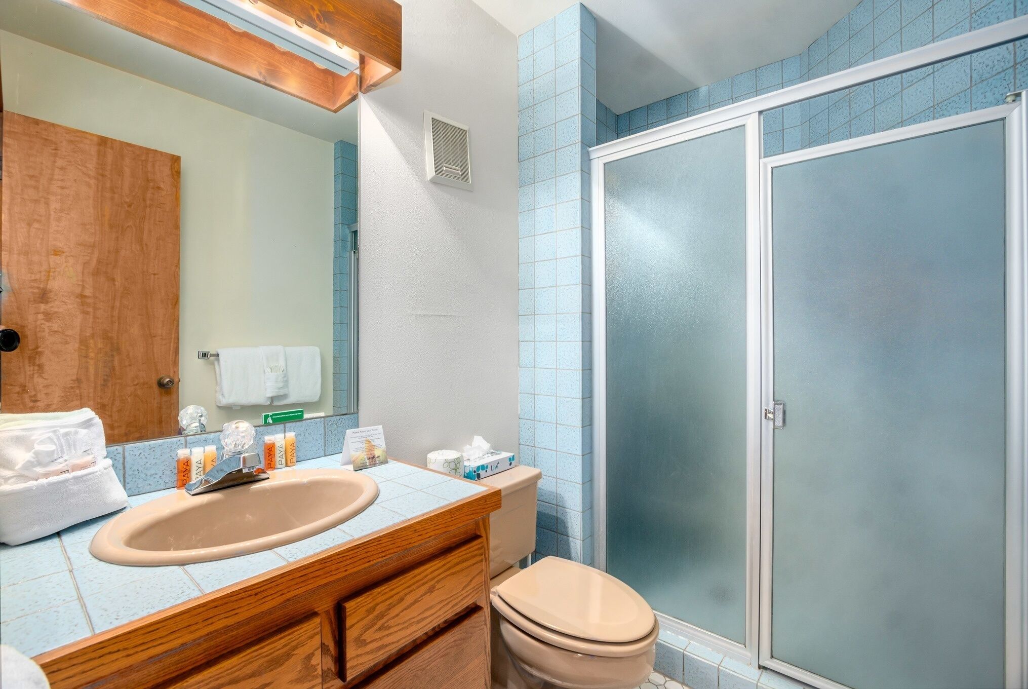 A bathroom with a wooden vanity, a sink, and a toilet.
