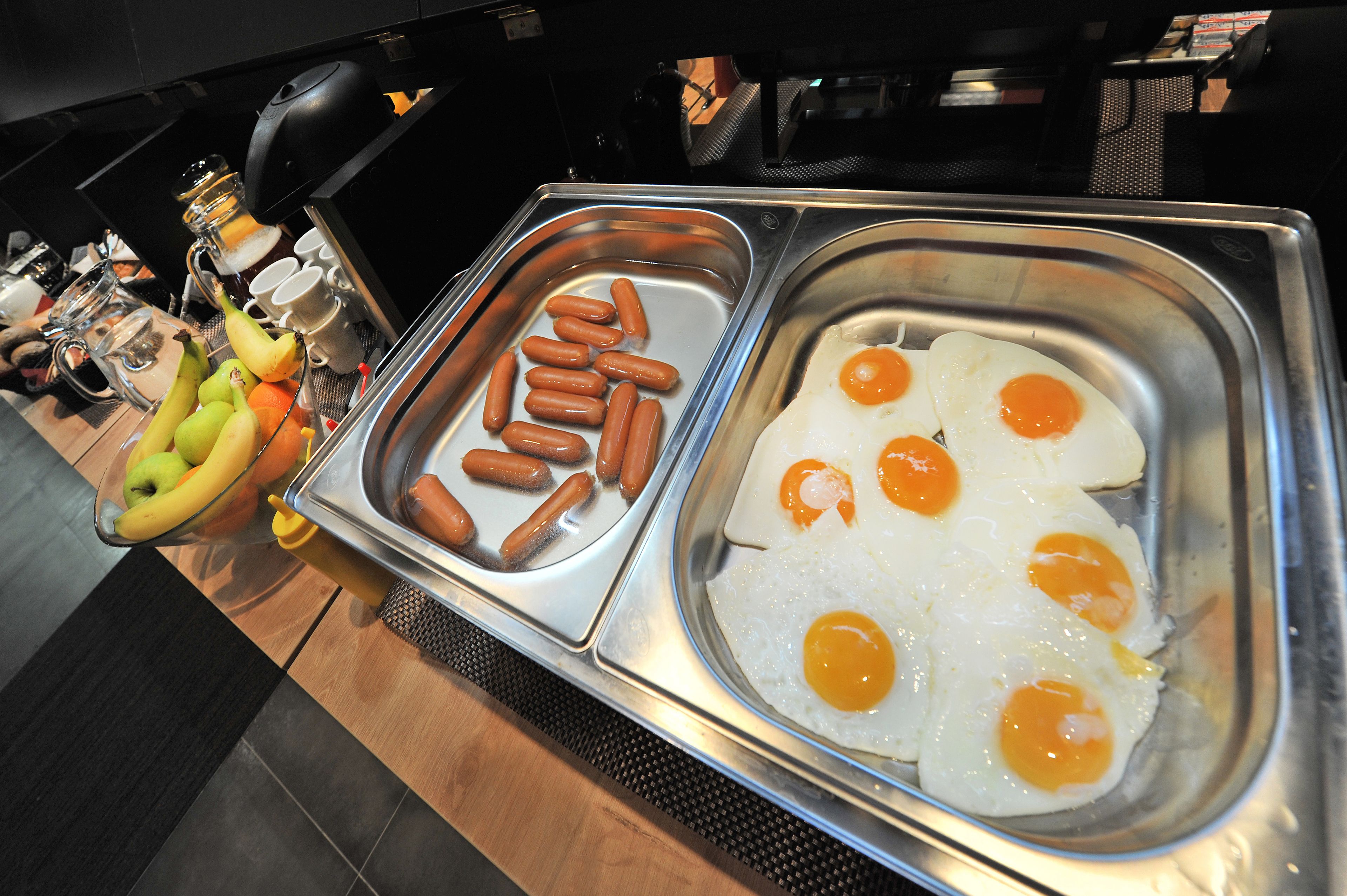 Un bufé con hot dogs y huevos fritos.