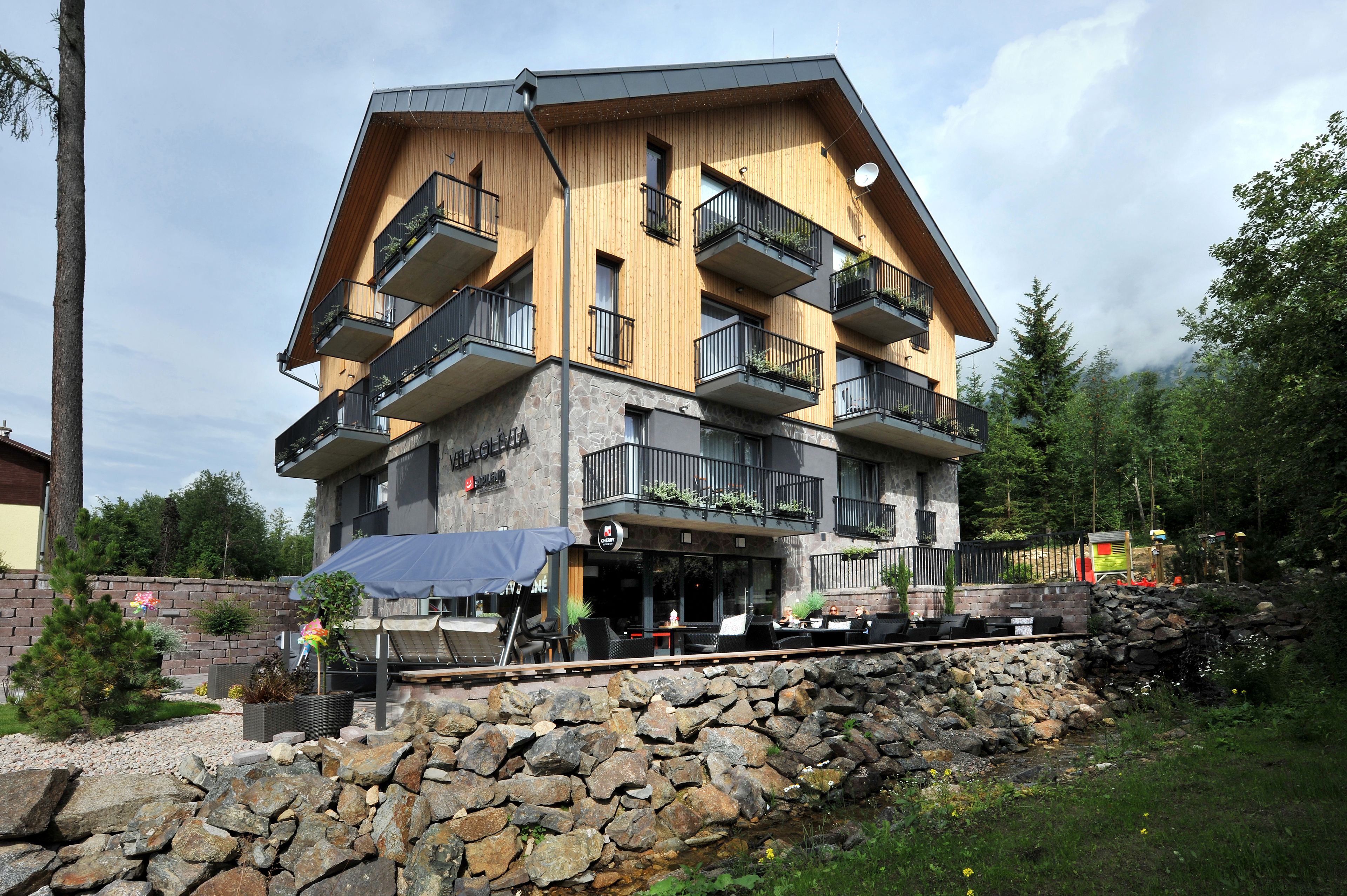 Ein mehrstöckiges Hotel mit Balkonen, Außenbereich und einer Steinschmalseite.