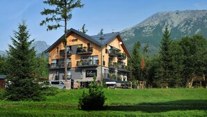 A multi-story hotel with balconies, a restaurant, and a view of mountains. - APLEND Vila Olivia (Vysoké Tatry)