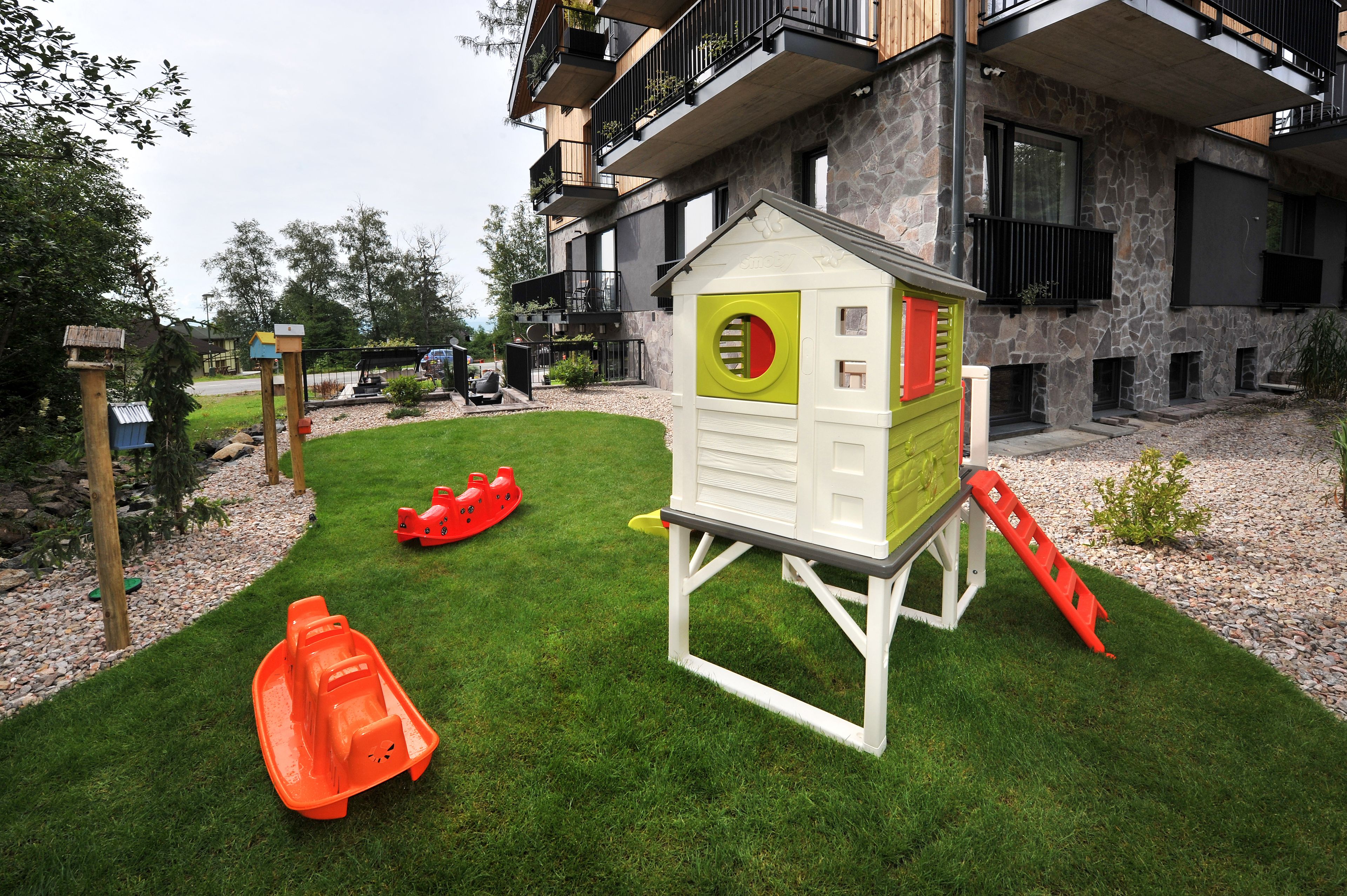 A children's play area with a small house, slides, and a boat.