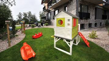 A children's play area with a small house, slides, and a boat.
