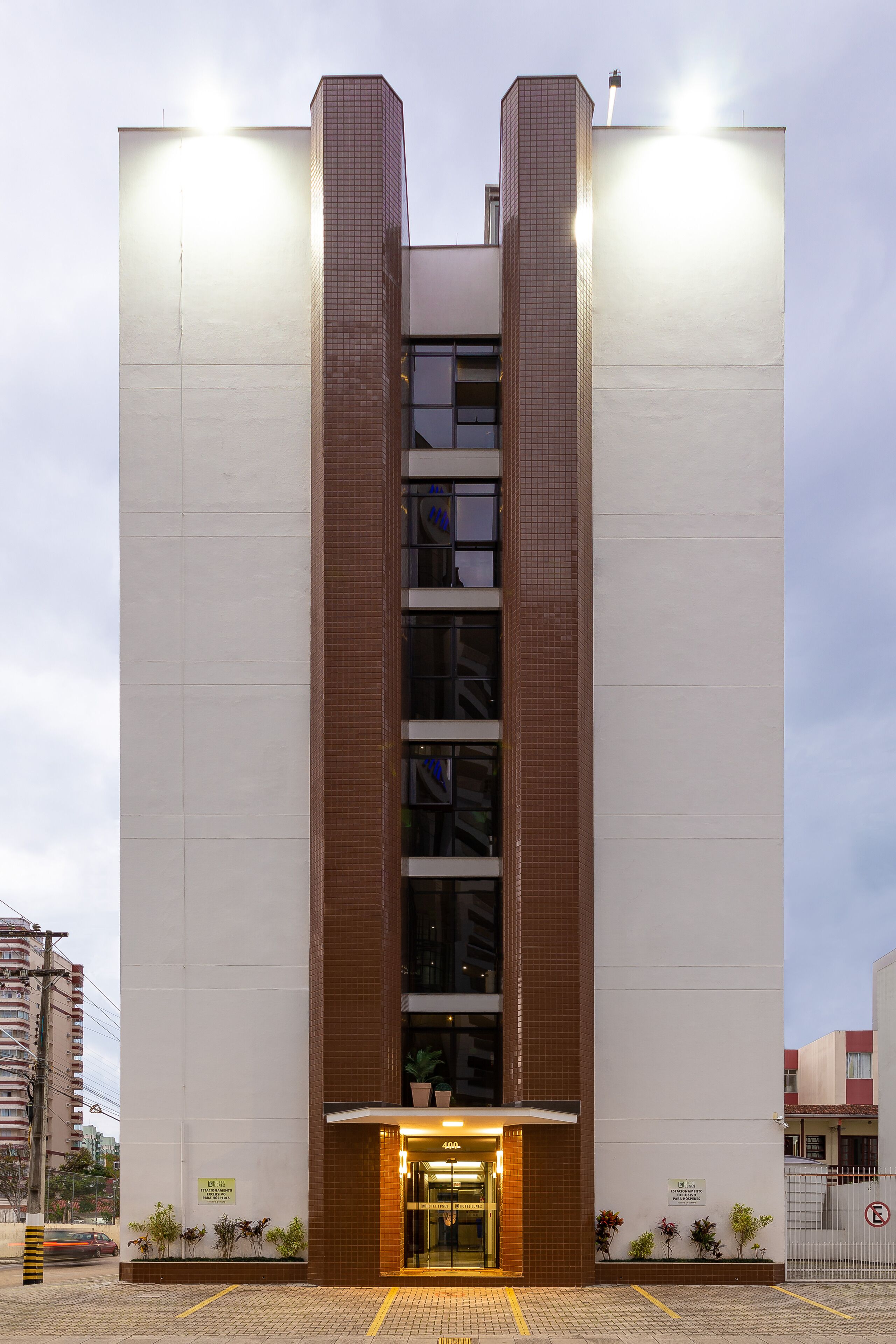 A modern building with a central entrance, large windows, and a brick facade.