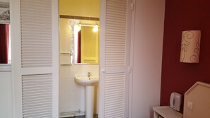 A bathroom with a sink, mirror, and white cabinets. - ACANTHE HOTEL (Bordeaux)
