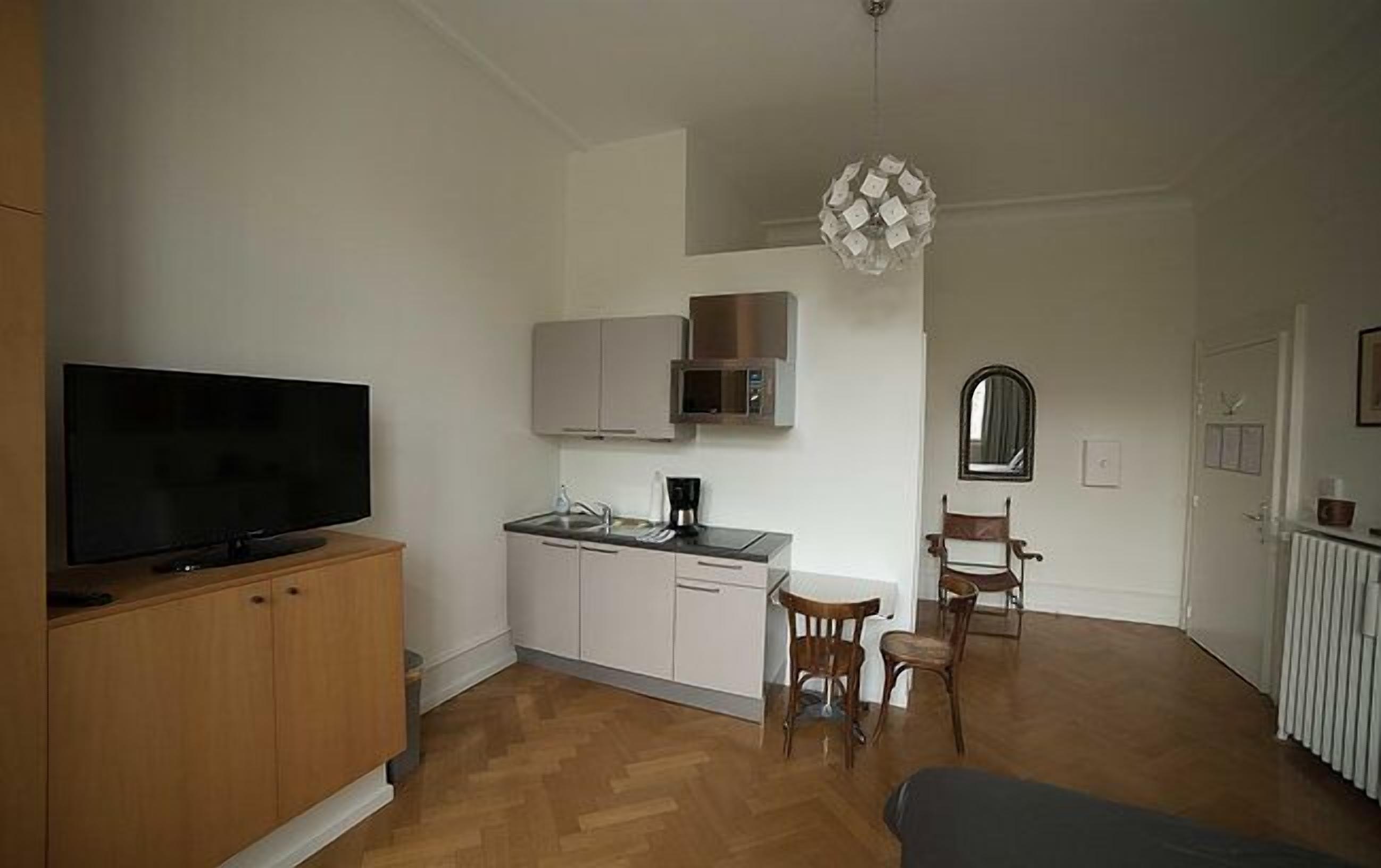 Ein gemütlicher Wohnbereich mit Küchenzeile, Essplatz und Fernseher.