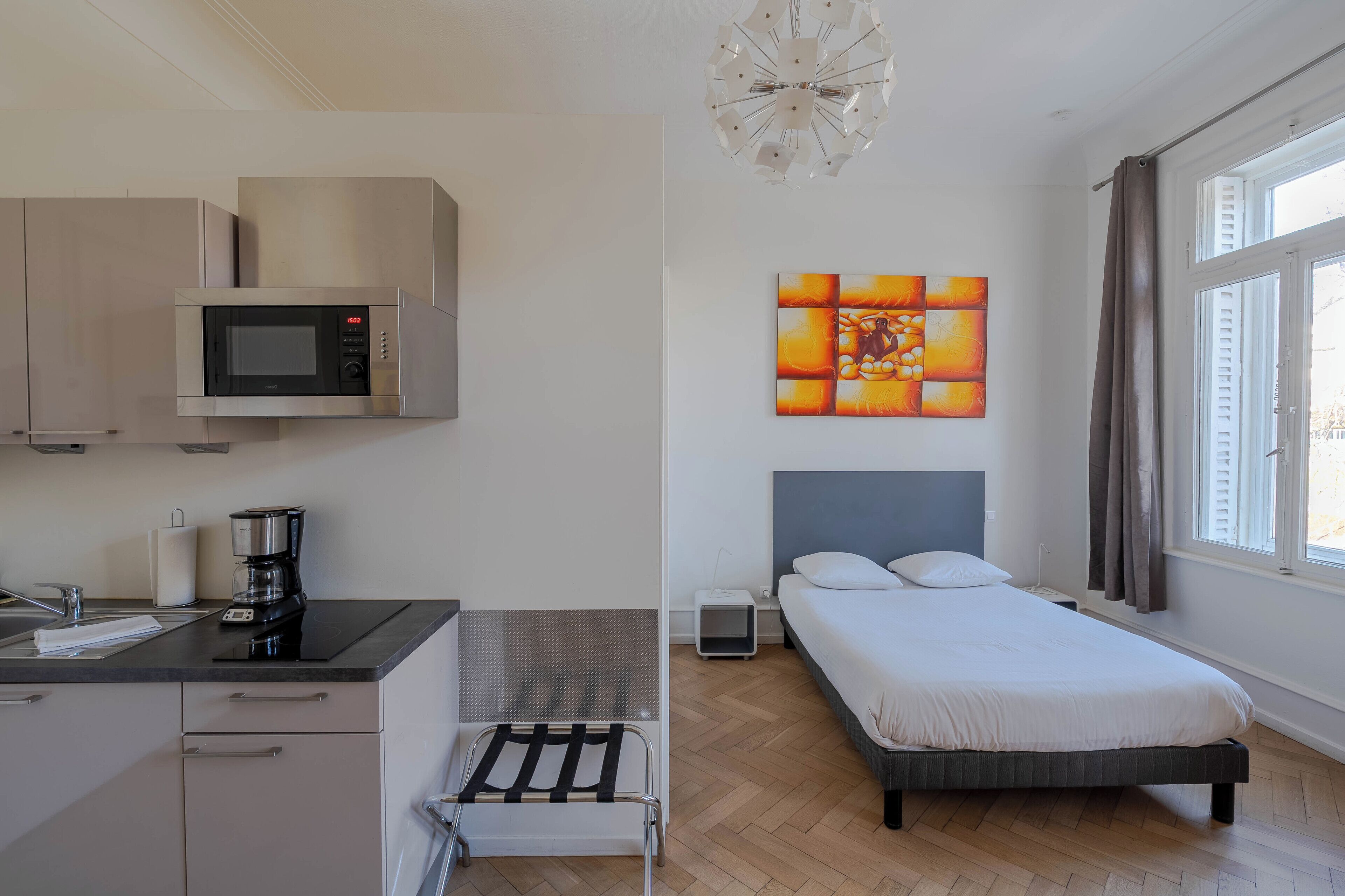 Ein modernes Schlafzimmer mit Bett, Nachttisch und einem fenster mit Vorhängen.
