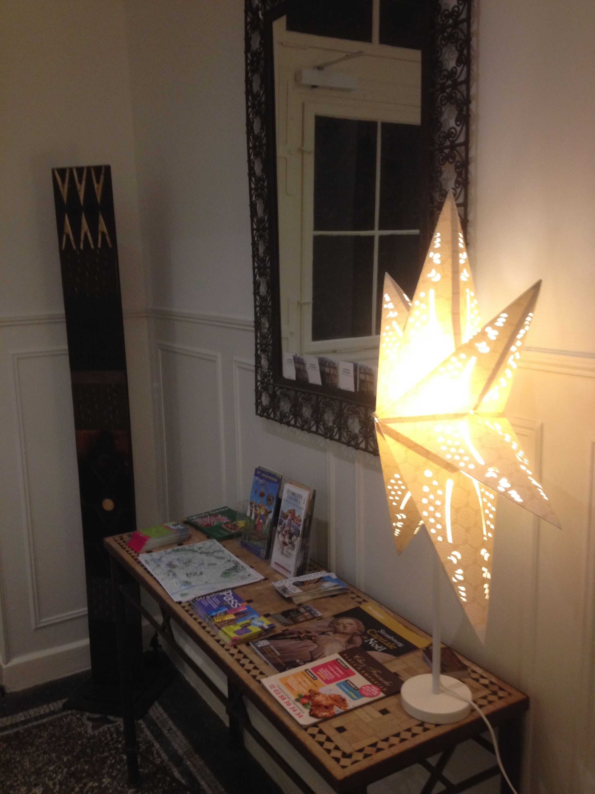 A desk with a lamp, books, and a mirror.