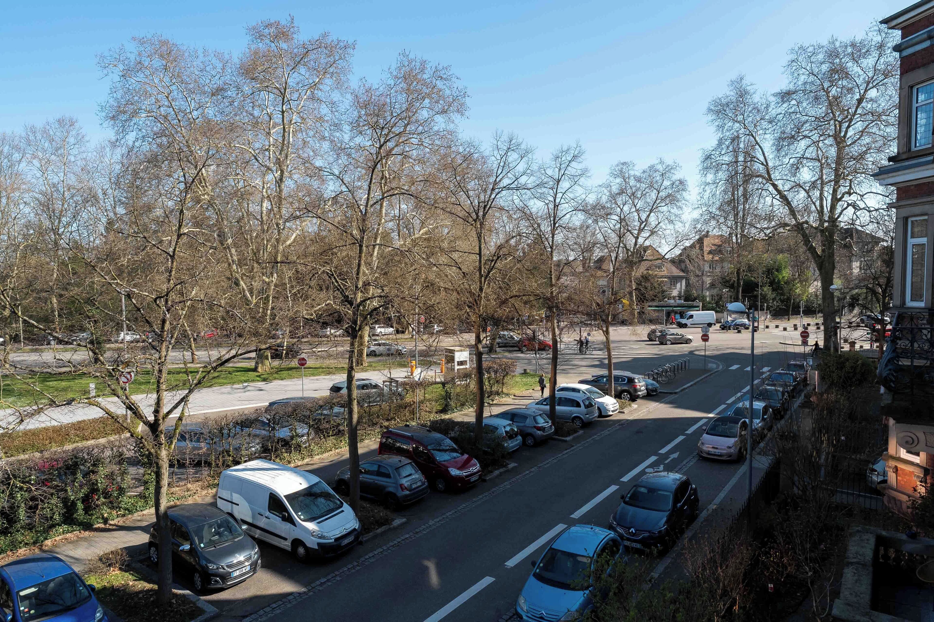 A parking lot with various cars and a white van.