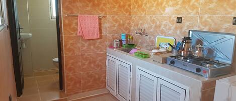 A kitchen with a gas stove, cabinets, and a sink.