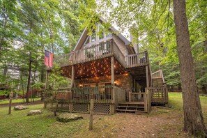 A cabin with a wooden deck, a staircase, and a porch area. - Swiss-Style Dog Friendly Chalet w/ Hot Tub (SWANTON)