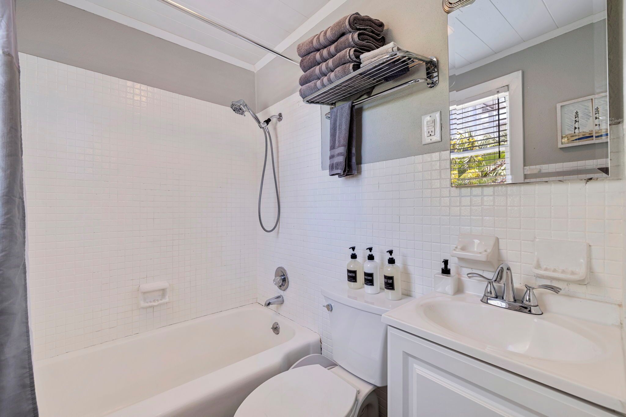 A bathroom with a bathtub, toilet, sink, and a towel rack.