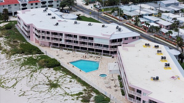 A multi-story hotel with a rooftop pool and a beach area.