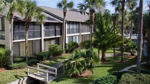 A modern building with a flat roof, surrounded by palm trees and well-maintained lawns. - Relax and enjoy your tropical getaway in this lovely Silver-rated condo! (Saint Augustine)