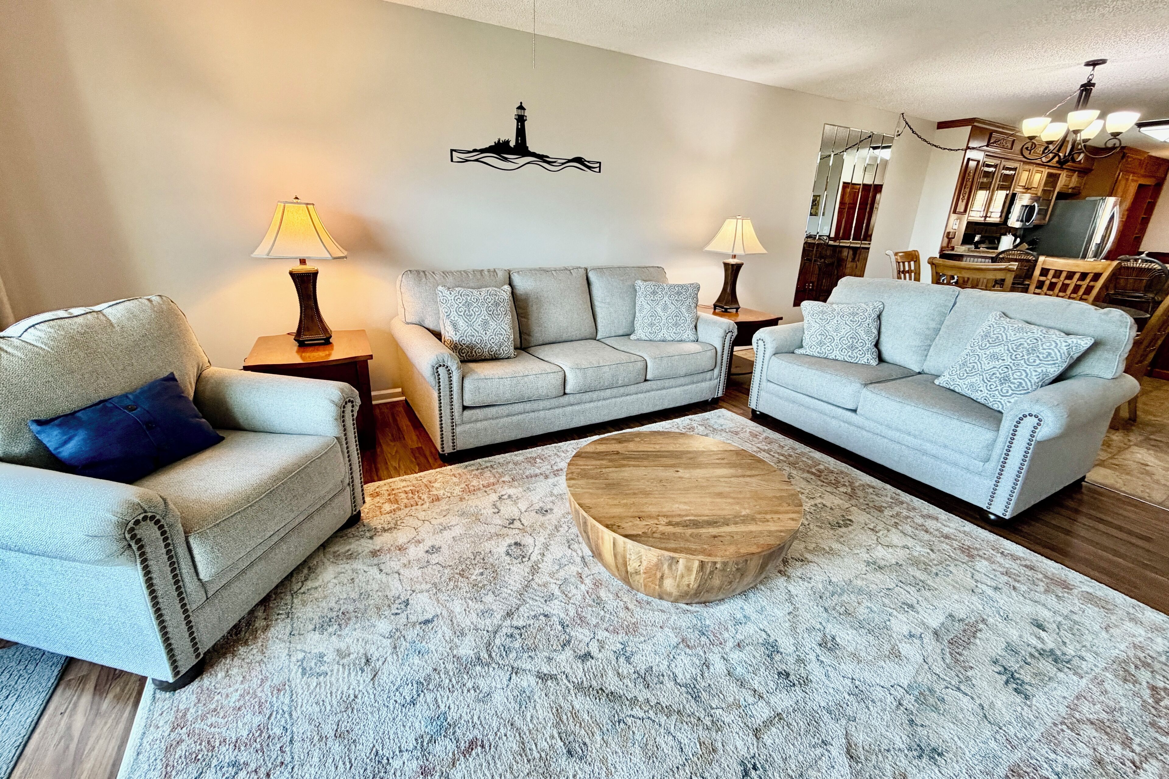 Ein Wohnzimmer mit zwei grauen Sofas, einem Holztisch und dekorativen Kissen.