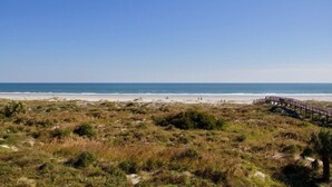 A beach with a wooden boardwalk leading to the ocean. - ENJOY FREE FUN EVERYDAY and a Cheerful ocean front condo with stunning view of the ocean. (Saint Augustine)