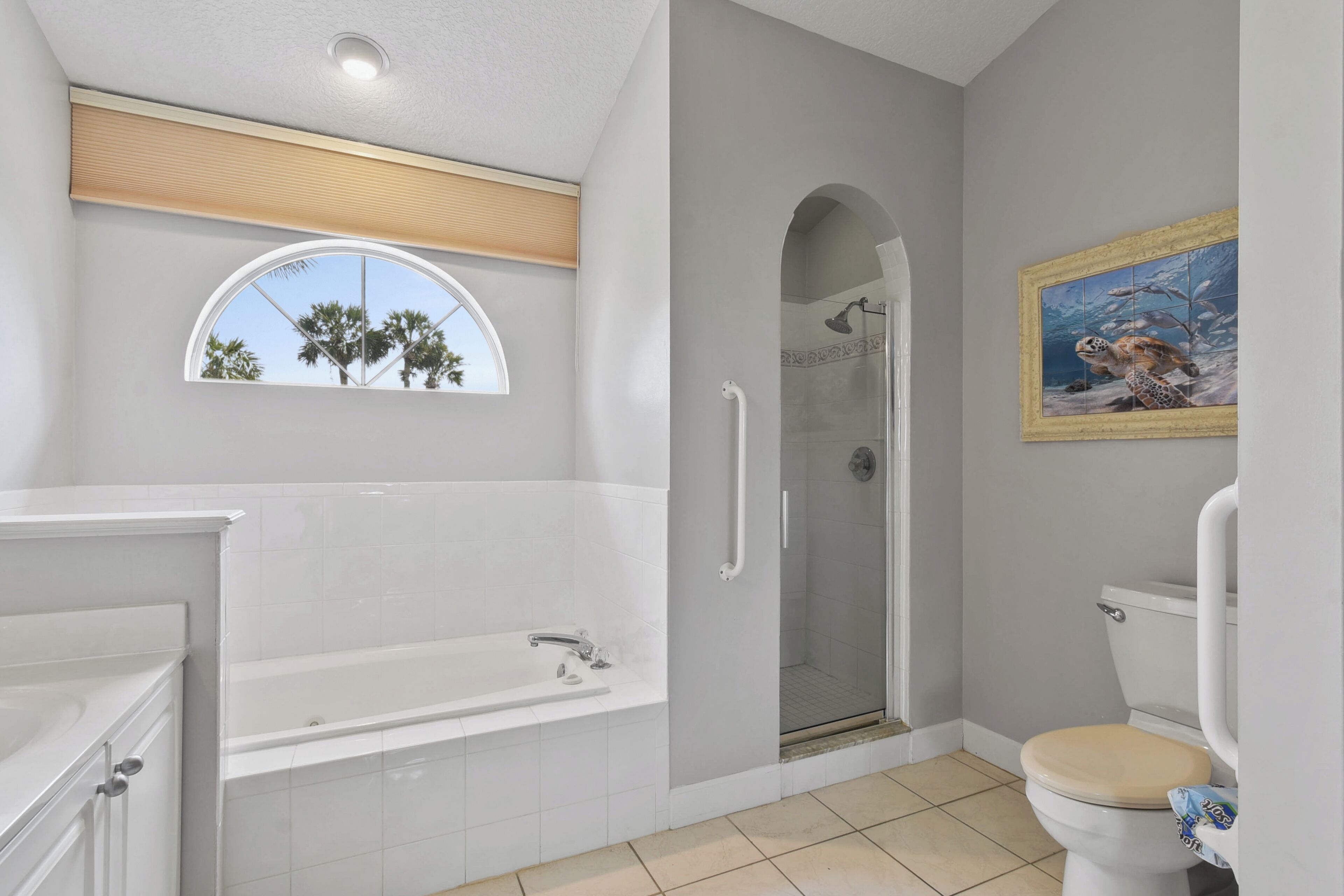 A modern bathroom with a bathtub, shower, and toilet.