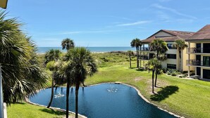 Ein Resort mit Swimmingpool, Palmen und Blick auf den Ozean.