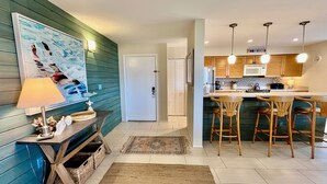 Una cucina moderna con mobili in legno, un forno a microonde e un'area pranzo con sgabelli da bar.