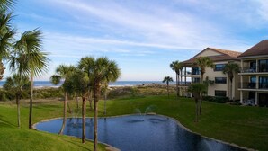 Un resort con piscina, palmeras y vista al océano.