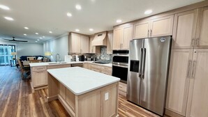 Una cocina moderna con armarios de madera, electrodomésticos de acero inoxidable y una isla central.