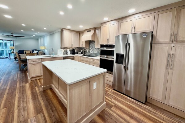 Une cuisine moderne avec des meubles en bois, des appareils en acier inoxydable et un îlot central.