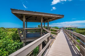 Une promenade en bois mène à une plateforme d’observation abritée, d’où l’on a une vue dégagée sur la végétation environnante et le ciel.