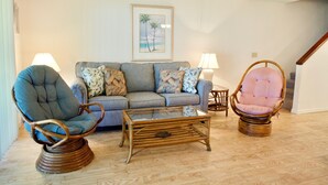 A living room with a sofa, two armchairs, a glass coffee table, and a framed picture on the wall. - Enjoy your morning coffee on your covered lanai, then head over to beach only a brisk walk away! (Saint Augustine)