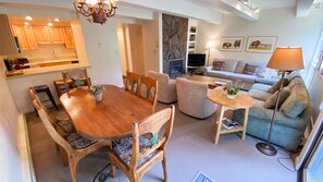 A spacious living area with a wooden dining table, comfortable seating, a sofa, and a television. - Updated Kitchen Cabinets in Vail Condo with In Unit Washer Dryer (Vail)