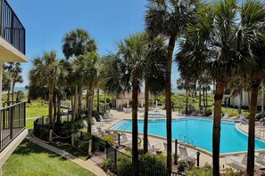 A pool area with palm trees, lounge chairs, and a clear blue sky. - FREE FUN DAILY while enjoying this comfy Gold-rated condo perfect for a couples vacation. (Saint Augustine)