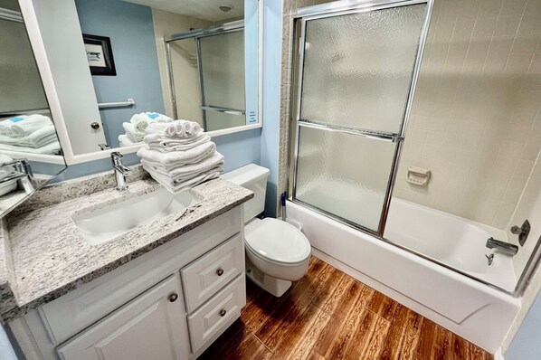 A bathroom with a sink, toilet, and glass-enclosed shower. - Spacious ocean front condo, perfect for sipping your morning coffee and enjoying the gentle waves! (Saint Augustine)