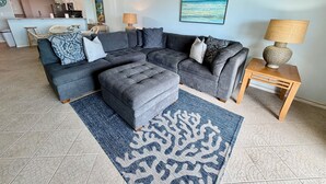 Una sala de estar con un sofá modular, una mesa de centro y una alfombra estampada.