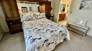 Ein Schlafzimmer mit einem großen Bett, einem Holzschrank und einer Bank.
