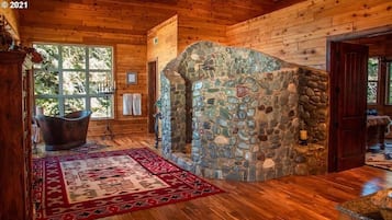 Relax by the stone fireplace, surrounded by rustic charm and a large bathtub.