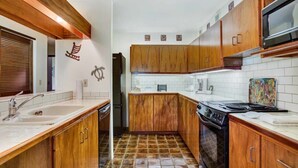 Una cocina con armarios de madera, estufa y microondas.