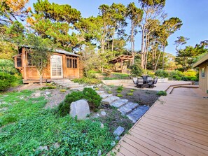 A wooden cabin with a patio, surrounded by lush greenery and tall trees. - Lx18 golfers dream retreat for concours delegance (Pebble Beach)