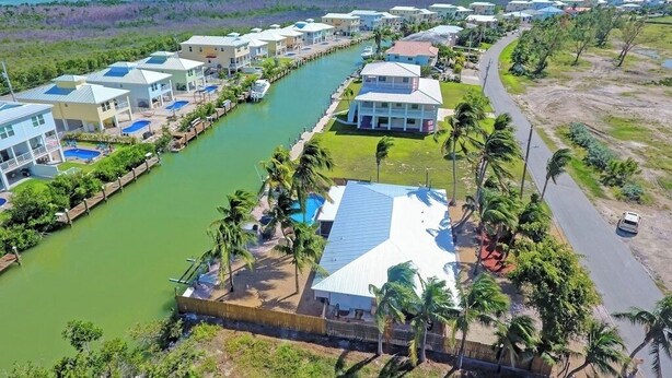 A coastal resort with multiple bungalow-style buildings, a marina, and a road. - P43 - Spacious 3 bedroom 3 bath home with Pool in the Sombrero Beach Area (Marathon)