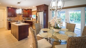 A modern kitchen with dark wood cabinets, stainless steel appliances, and a central island. - P43 - Spacious 3 bedroom 3 bath home with Pool in the Sombrero Beach Area (Marathon)