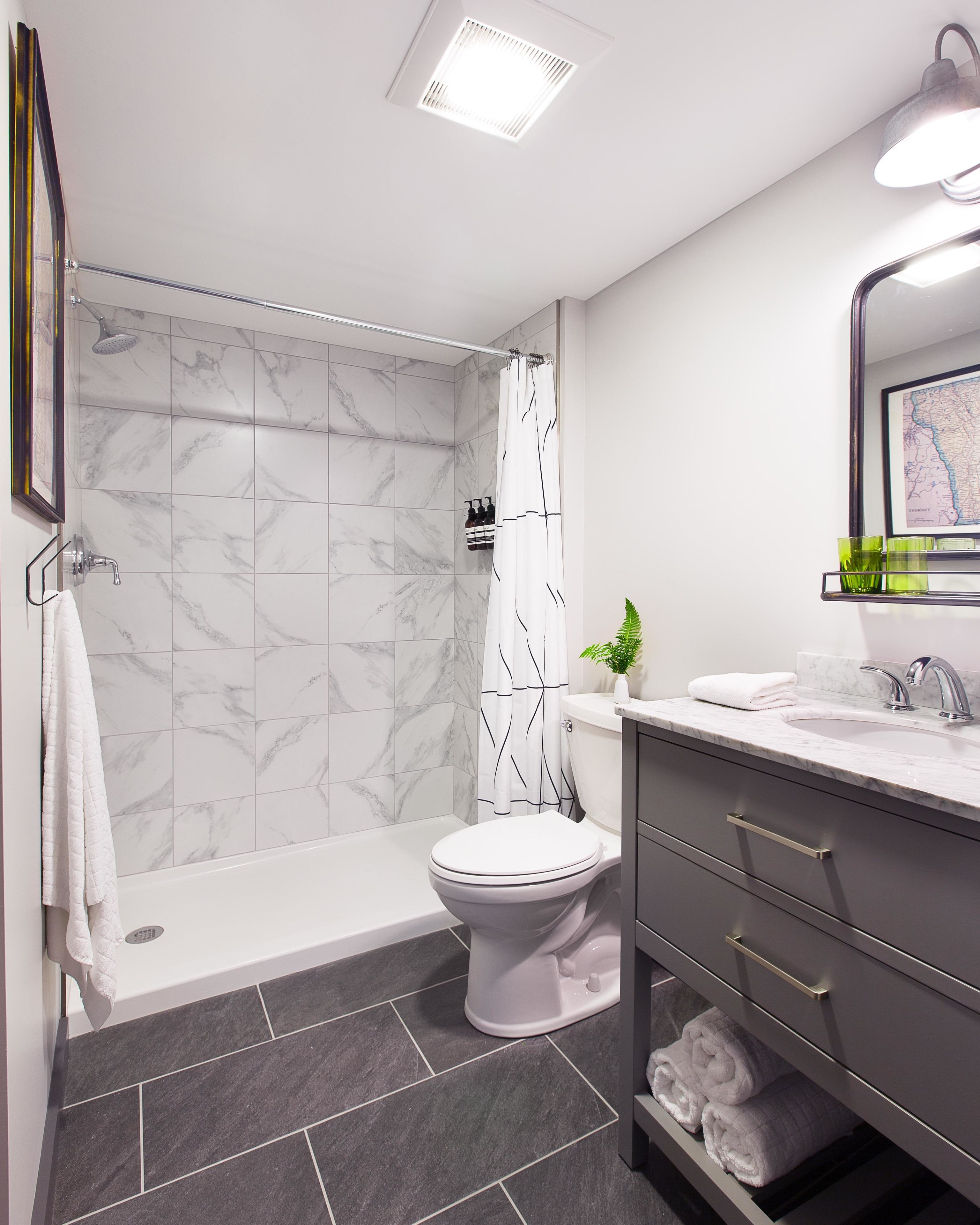 A modern bathroom with a shower, toilet, and vanity.