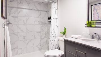 A modern bathroom with a shower, toilet, and vanity.