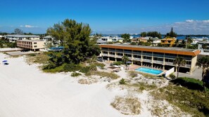 Un hôtel situé en bord de mer, doté d’une piscine, de plusieurs balcons et offrant une vue sur l’océan.