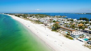 A coastal resort with beachfront properties, a marina, and a clear view of the ocean.