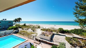 Un espace piscine offrant une vue sur la plage et l’océan.